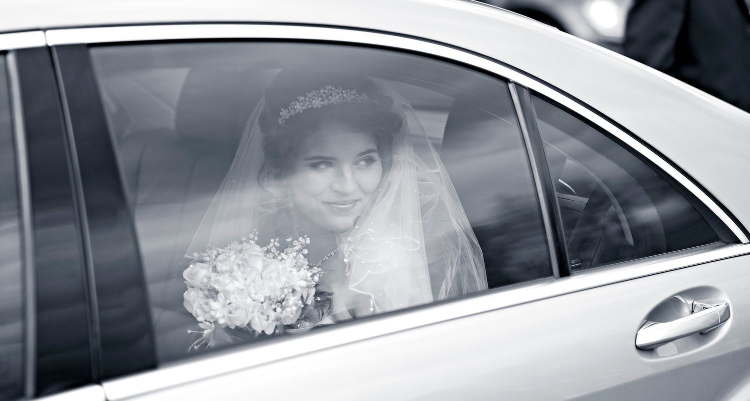 Wedding car: bride through window. Black and white photograph